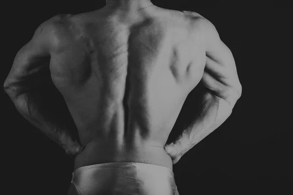 Bodybuilder on a dark background. — Stock Photo, Image