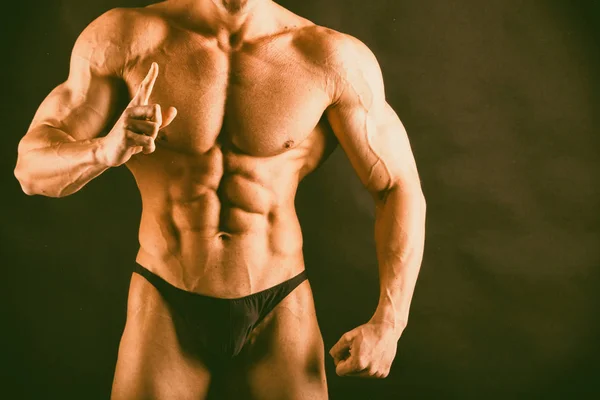 Bodybuilder auf dunklem Hintergrund. — Stockfoto