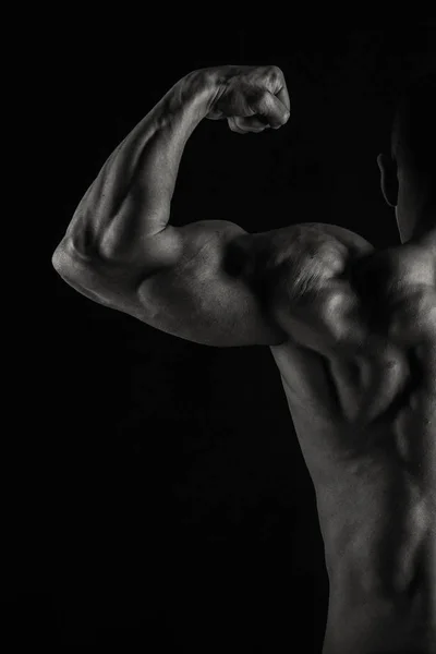 Corpo masculino muscular em um fundo escuro . — Fotografia de Stock