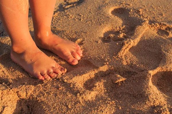 Pés de criança na areia e no mar — Fotografia de Stock