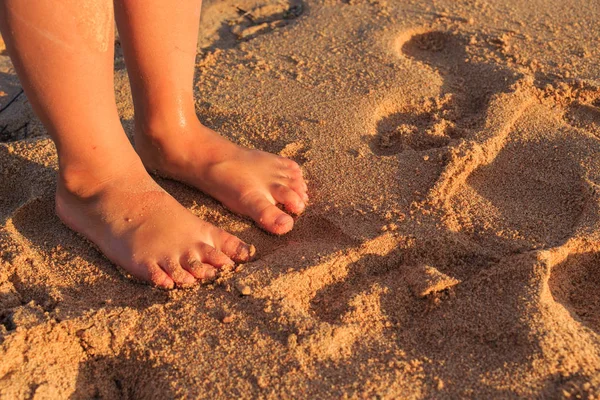 Pés de criança na areia e no mar — Fotografia de Stock