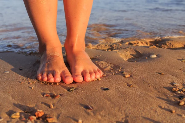 Children's feet in the sand and the sea — Stock Photo, Image