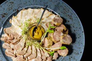 bir tabağa dilimlenmiş et ve sosis