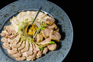 bir tabağa dilimlenmiş et ve sosis