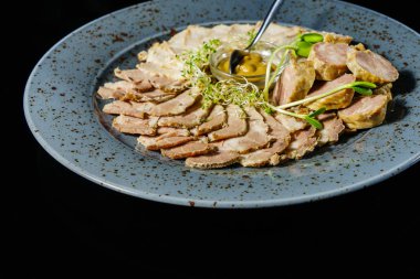 bir tabağa dilimlenmiş et ve sosis