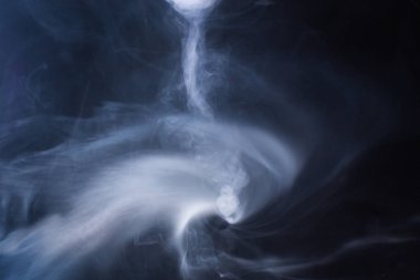 Kalın beyaz karanlık bir arka plan üzerinde duman.