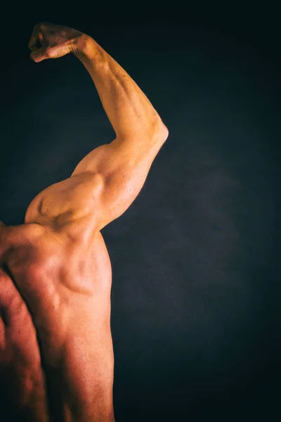 Culturista posando en diferentes poses demostrando sus músculos . —  Fotos de Stock
