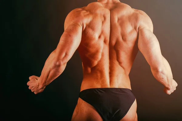 Bodybuilder showing his back and biceps muscles, personal fitnes