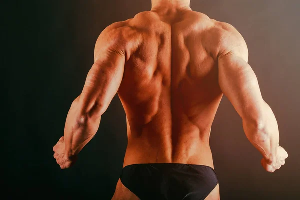 Bodybuilder showing his back and biceps muscles, personal fitnes