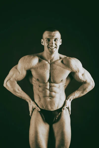 Bodybuilder  on a dark background. — Stock Photo, Image