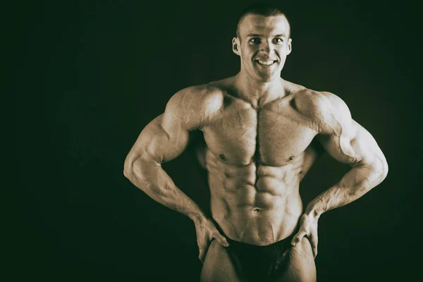 Bodybuilder auf dunklem Hintergrund. — Stockfoto