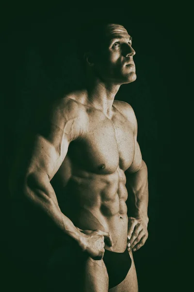 Bodybuilder auf dunklem Hintergrund. — Stockfoto