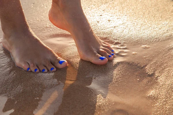 Beautiful legs on wet sand — Stock Photo, Image