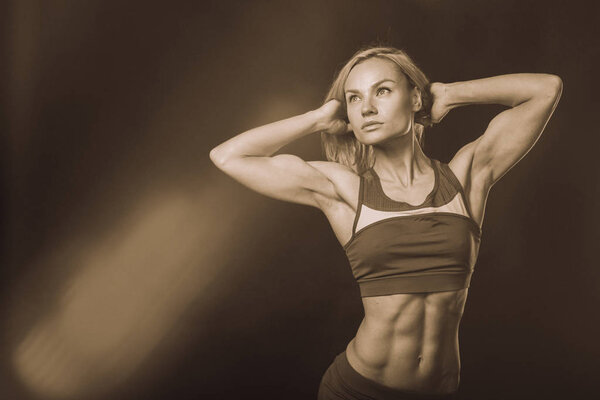 Professional fitness athlete on a dark background.