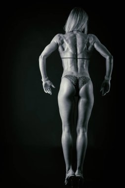 Karanlık bir arka plan üzerinde profesyonel fitness atlet.