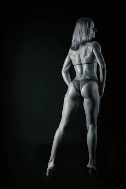 Karanlık bir arka plan üzerinde profesyonel fitness atlet.