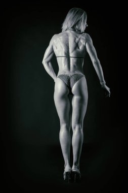 Karanlık bir arka plan üzerinde profesyonel fitness atlet.