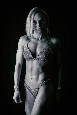 Karanlık bir arka plan üzerinde profesyonel fitness atlet.