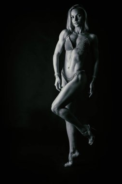 Karanlık bir arka plan üzerinde profesyonel fitness atlet.