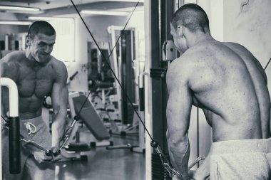 Güçlü bir adam spor salonunda devreye girer. Erkekler güç fitness.