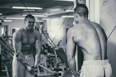 Güçlü bir adam spor salonunda devreye girer. Erkekler güç fitness.