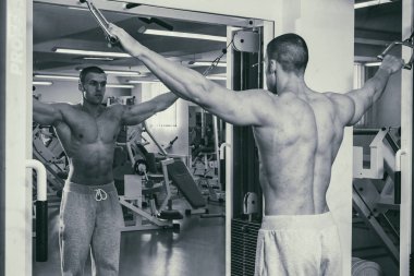 Güçlü bir adam spor salonunda devreye girer. Erkekler güç fitness.