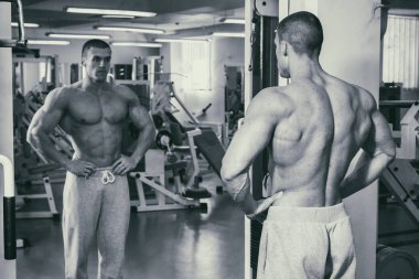 Güçlü bir adam spor salonunda devreye girer. Erkekler güç fitness.