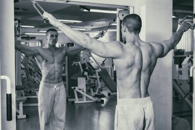 Güçlü bir adam spor salonunda devreye girer. Erkekler güç fitness.