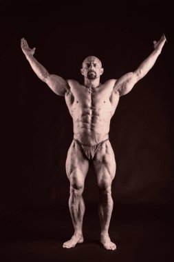 Karanlık bir arka plan üzerinde güçlü kas adam.