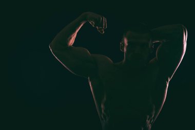 Karanlık bir arka plan üzerinde güzel vücut geliştirmeci siluet.