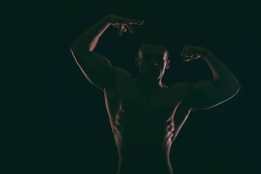 Karanlık bir arka plan üzerinde güzel vücut geliştirmeci siluet.