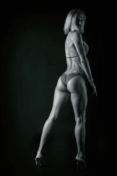 Karanlık bir arka plan üzerinde profesyonel fitness atlet. — Stok fotoğraf