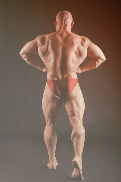 Bodybuilder zeigt seine Rücken- und Bizeps-Muskeln, persönliche Fitness — Stockfoto