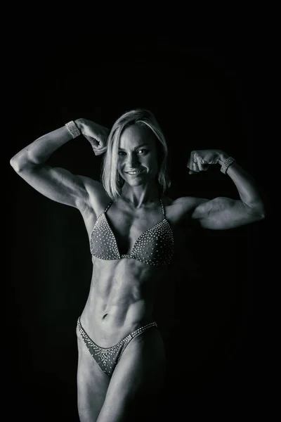 Professional fitness athlete on a dark background. — Stock Photo, Image