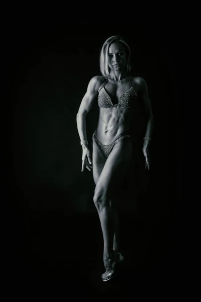 Atleta de fitness profesional sobre un fondo oscuro . — Foto de Stock