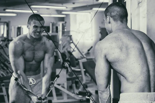 Un hombre fuerte está ocupado en el gimnasio. Fuerza física de los hombres . —  Fotos de Stock