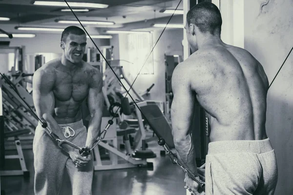 Un homme fort est engagé dans la salle de gym. Forme physique des hommes . — Photo