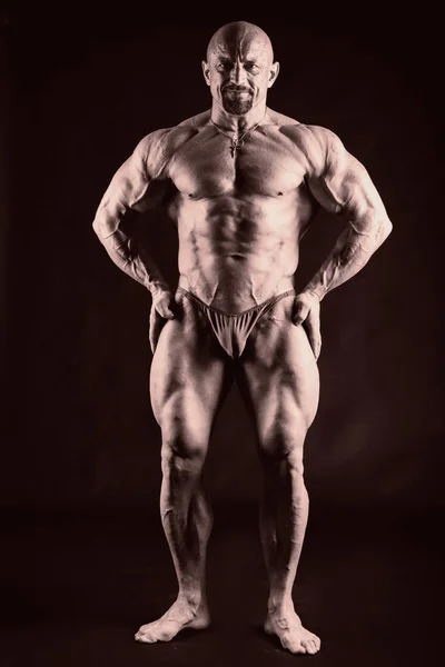 Forte uomo muscoloso su uno sfondo scuro . — Foto Stock
