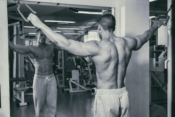 Un hombre fuerte está ocupado en el gimnasio. Fuerza física de los hombres . — Foto de Stock
