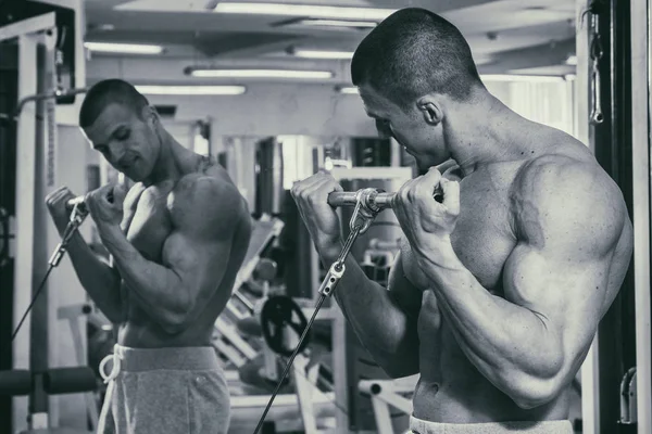 Un hombre fuerte está ocupado en el gimnasio. Fuerza física de los hombres . — Foto de Stock