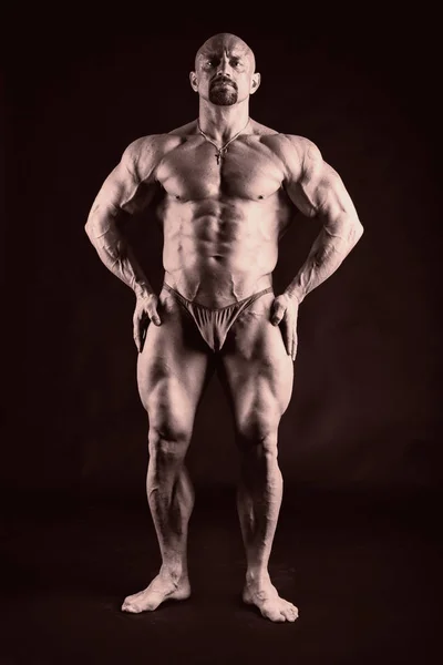 Kräftiger muskulöser Mann auf dunklem Hintergrund. — Stockfoto