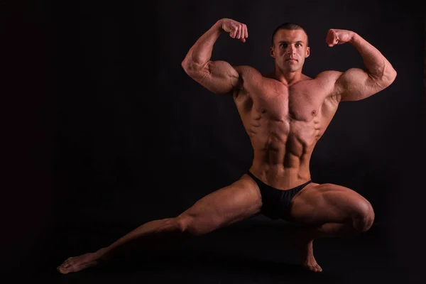 Silhouette schöner Bodybuilder auf dunklem Hintergrund. — Stockfoto