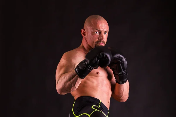 Hombre musculoso fuerte sobre un fondo oscuro . — Foto de Stock