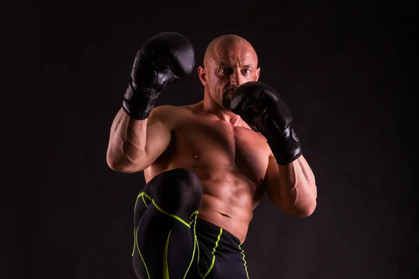 Hombre musculoso fuerte sobre un fondo oscuro . — Foto de Stock