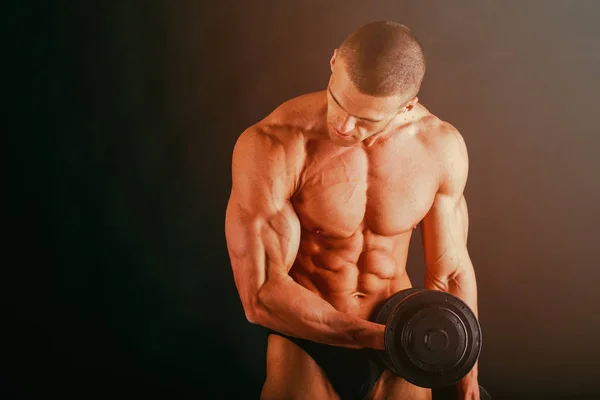 Primer plano de un joven musculoso sobre fondo oscuro —  Fotos de Stock