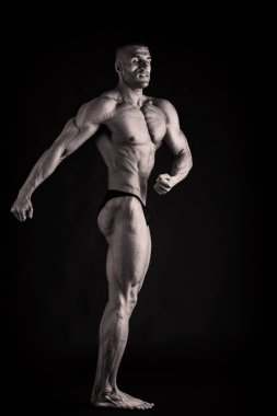 Kaslı bir genç adam koyu arka plan üzerinde closeup