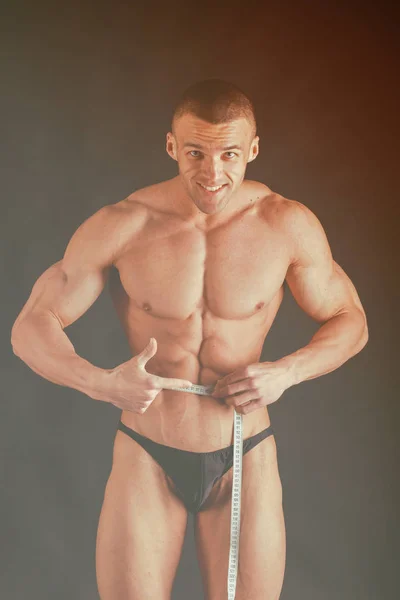 Крупный план мускулистого молодого человека на тёмном фоне — стоковое фото