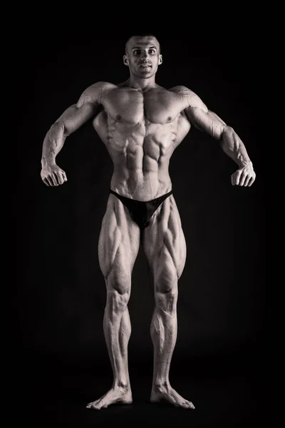 Närbild av en muskulös ung man på mörk bakgrund — Stockfoto