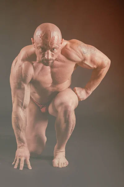 Bodybuilder auf dunklem Hintergrund. — Stockfoto