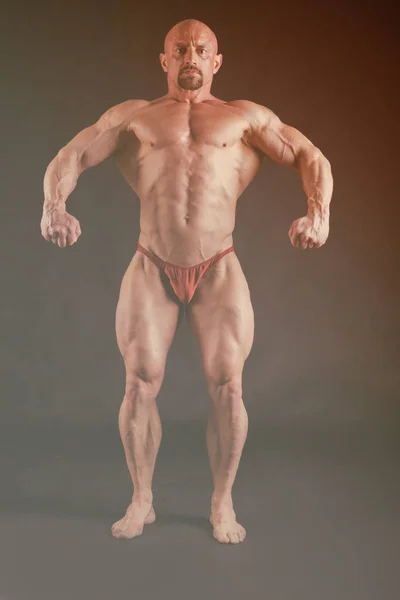 Bodybuilder auf dunklem Hintergrund. — Stockfoto